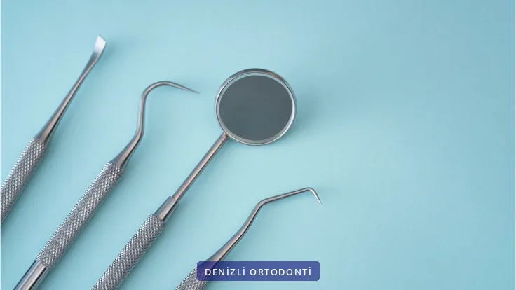 Mavi zemin üzerinde ağız aynası ve muayene el aletleri